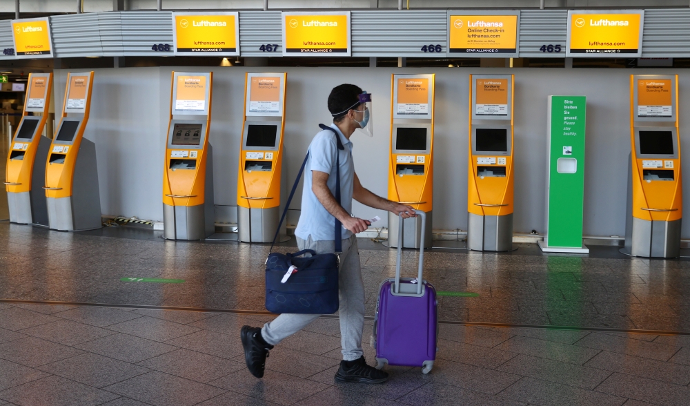 A passenger rushes past check-in desks prior to the first Lufthansa charter flight for Tianjin, China after the lockdown, as the spread of the coronavirus disease (COVID-19) continues, at the airport in Frankfurt, Germany, May 29, 2020. REUTERS/Kai Pfaffe