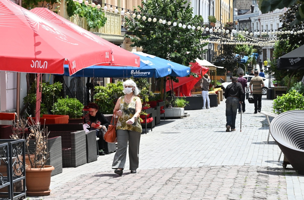 A woman wearing a protective face mask walks past a restaurant in Tbilisi on June 1, 2020, as Georgia lifts most of the restrictions on economic activity that were imposed as part of measures to contain the coronavirus spread. AFP / Vano Shlamov
