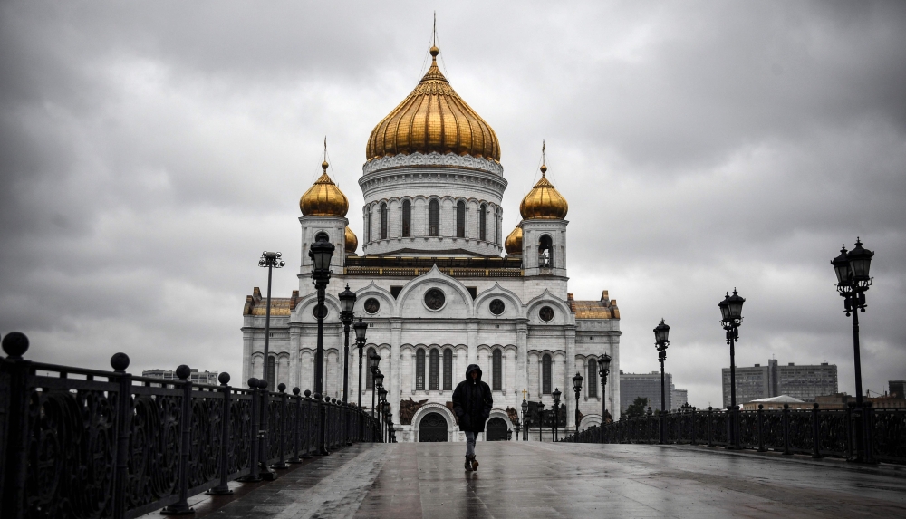 A woman walks in front of Christ-the-Savior cathedral in central, the main Russian Orthodox church in central Moscow, on June 2, 2020, amid the outbreak of COVID-19, caused by the novel coronavirus, as Moscow authorities started opening churches, mosques 