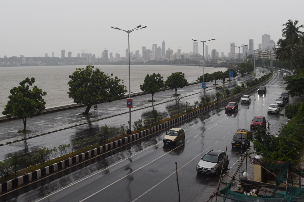 Commuters drive along Marine Drive as rain falls in Mumbai on June 3, 2020 as cyclone Nisarga barrels towards India's western coast. / AFP / Punit PARANJPE
