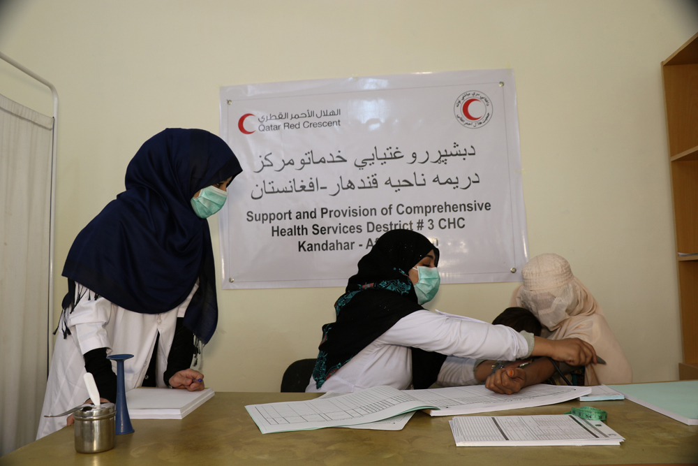 Medical workers examine a patient at a health center being operated by the Qatar Red Crescent Society in Kandahar, Afghanistan.