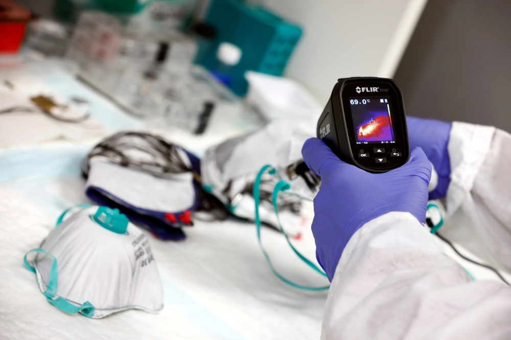 A researcher takes part in a demonstration for Reuters at a laboratory, June 10, 2020. Reuters/Amir Cohen