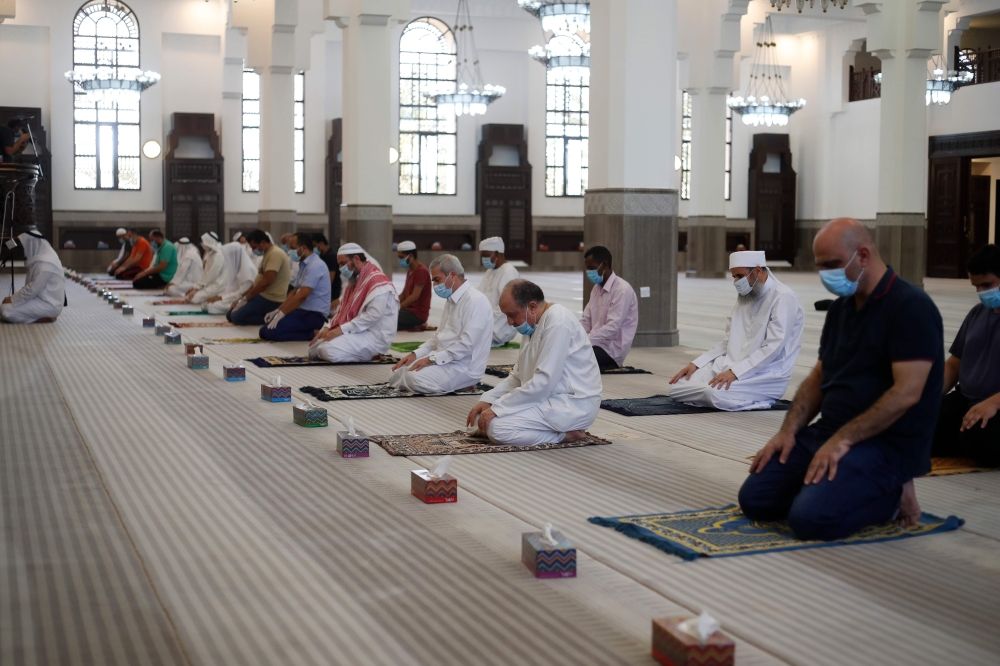 Muslim worshippers pray in a mosque in the Qatari capital Doha on June 15, 2020, after the easing of the restrictions imposed by the coronavirus pandemic. / AFP / KARIM JAAFAR
