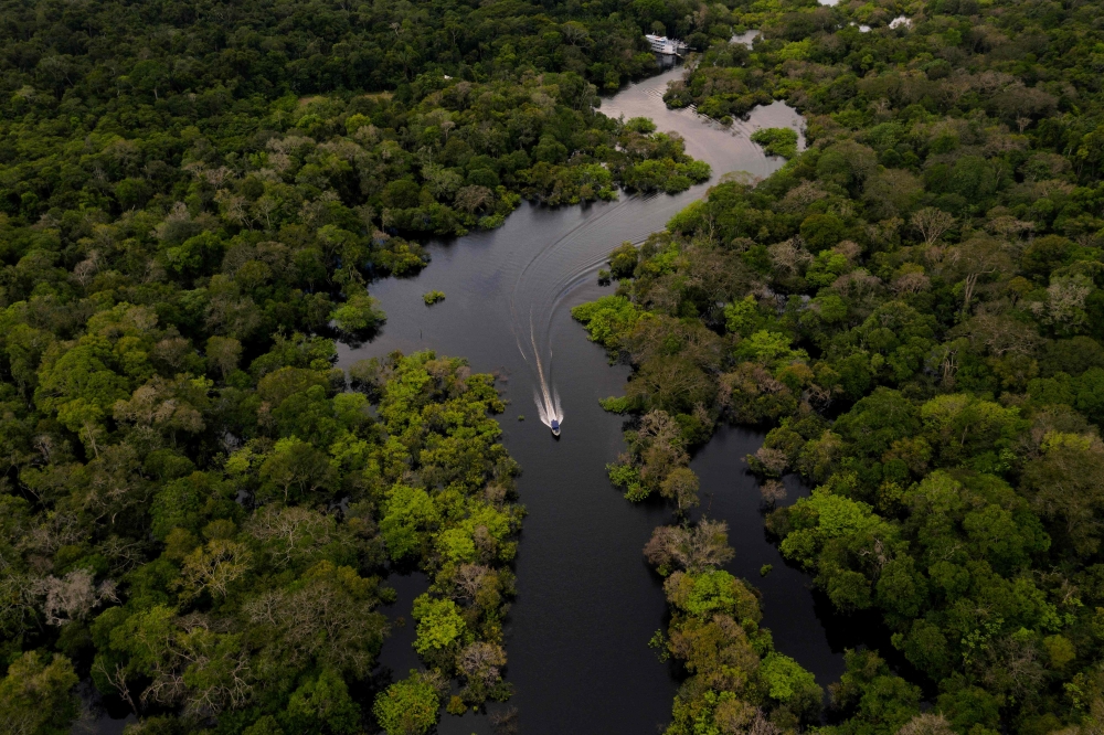 In this aerial file photo taken on March 15, 2020 a boat is seen speeding on the Jurura river in the municipality of Carauari, Amazonas state, in the heart of the Brazilian Amazon Rainforest. AFP / Florence GOISNARD