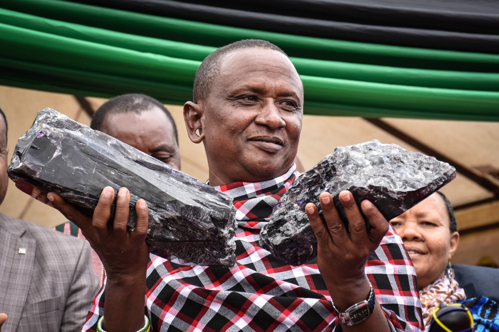 Tanzanian small-scale miner Saniniu Kuryan Laizer, 52, poses with two of the biggest of the country's precious gemstones, Tanzanite, as a millionaire during the ceremony for his historical discovery in Manyara, northern Tanzania, on June 24, 2020. AFP / F
