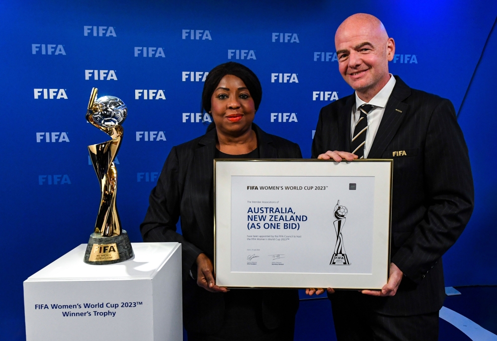 FIFA Secretary General Fatma Samoura (L) and FIFA President Gianni Infantino pose next to the Women's World Cup Trophy after the announcement that Australia/New-Zealand are the winning hosts for the FIFA Women's World Cup 2023 (FWWV23) during a virtual FI
