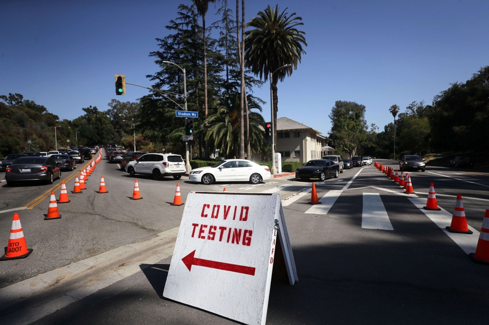 People in cars are lined up to be tested for COVID-19 as they make their way to a parking lot at Dodger Stadium amid the coronavirus pandemic on June 26, 2020 in Los Angeles, California. Mario Tama/Getty Images/AFP 