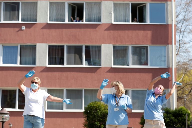 Careworkers of a nursing home enjoy as the MAV Symphony Orchestra plays classical music recordings on loudspeakers of a car going around the city to cheer up people under lockdown, during the coronavirus disease (COVID-19) outbreak in Budapest, Hungary, A