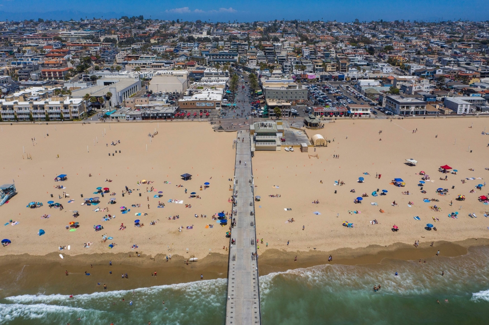 TOPSHOT - An aerial view shows people on the beach during a heatwave as coronavirus cases reach new record levels in states across the nation, in Hermosa Beach, California, on July 12, 2020. / AFP / DAVID MCNEW
