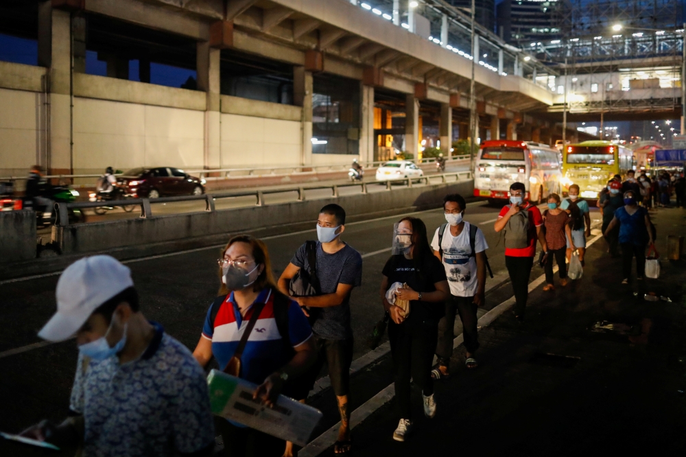 Passengers wearing face masks for protection against the coronavirus disease (COVID-19) queue to ride a bus in Quezon City, Metro Manila, Philippines, July 21, 2020. REUTERS/Eloisa Lopez