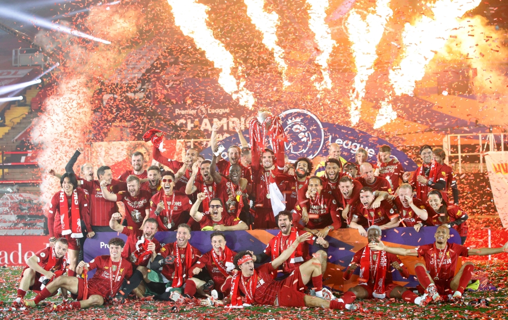 Liverpool's English midfielder Jordan Henderson (C) lifts the Premier League trophy during the presentation following the English Premier League football match between Liverpool and Chelsea at Anfield in Liverpool, north west England on July 22, 2020.  / 