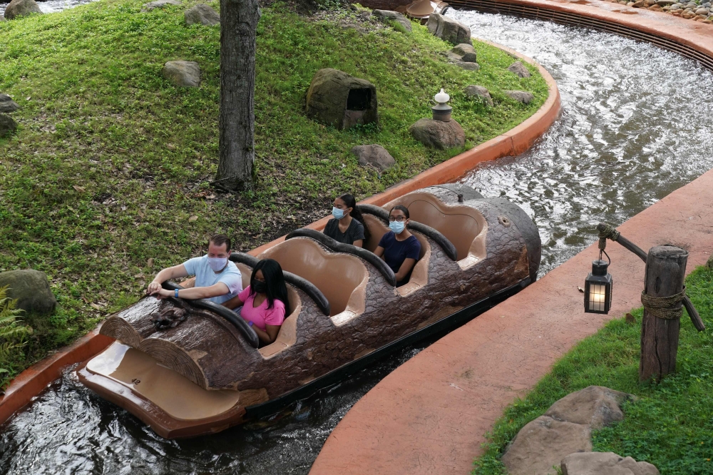 Social distancing seating measures are in place as people wearing facemasks ride Splash Mountain at Walt Disney World Resort's Magic Kingdom during the COVID-19 pandemic in Orlando on July 23, 2020. / AFP / Bryan R. Smith