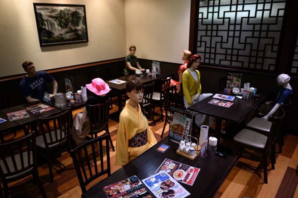 Mannequins, used as a method to maintain social distancing among diners, are seen seated in a restaurant in the Akabane district of Tokyo on July 26, 2020, amid the COVID-19 coronavirus pandemic. / AFP / Philip Fong