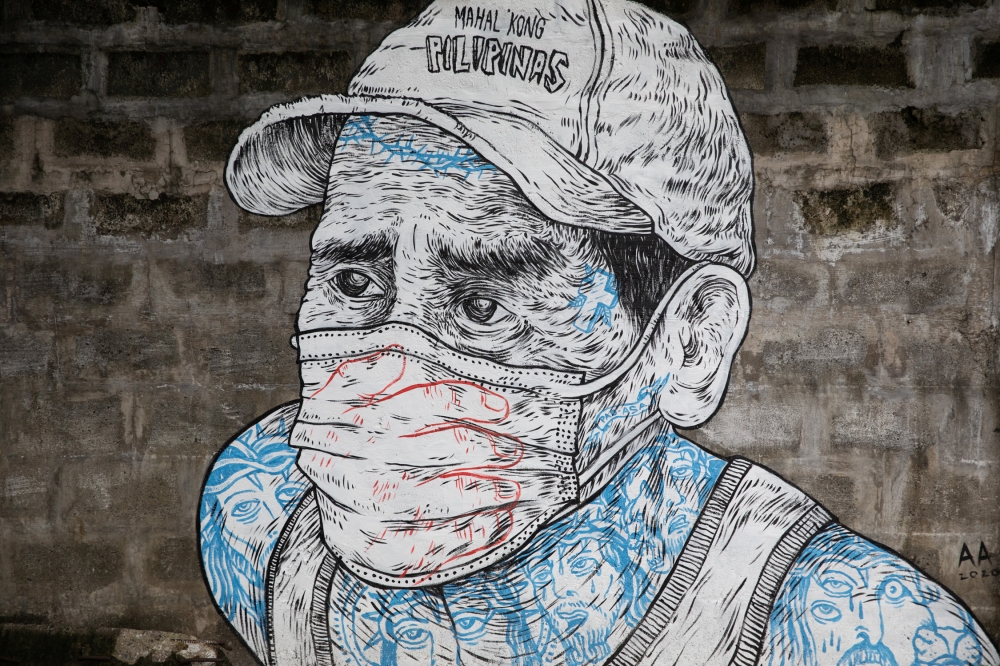 A mural of a man wearing a mask is pictured on a sidewalk amid the coronavirus disease (COVID-19) outbreak in Quezon City, Metro Manila, Philippines, July 30, 2020. REUTERS/Eloisa Lopez 