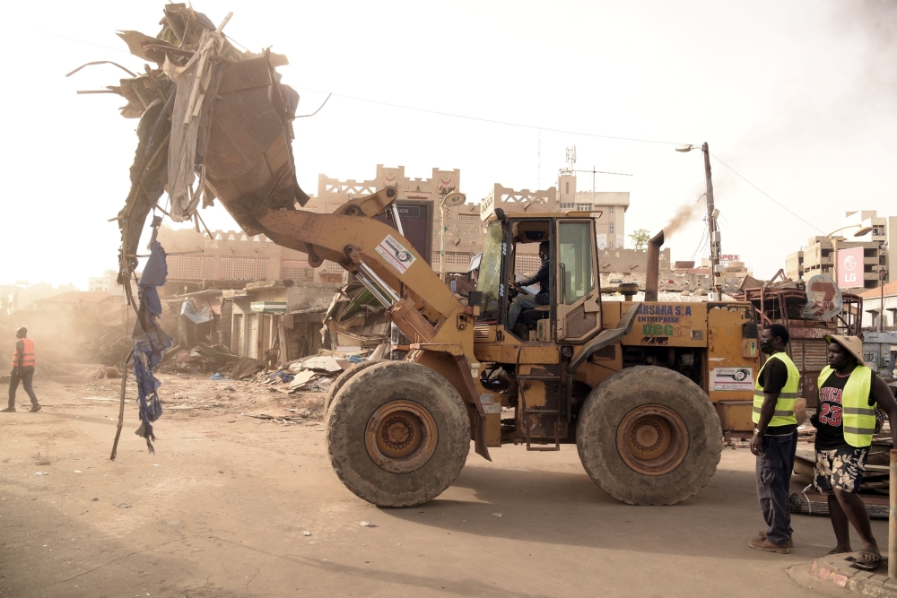 Caterpillars are seen in action at the start of the demolition work of the Sandaga market in Dakar, on August 2, 2020. / AFP / Seyllou