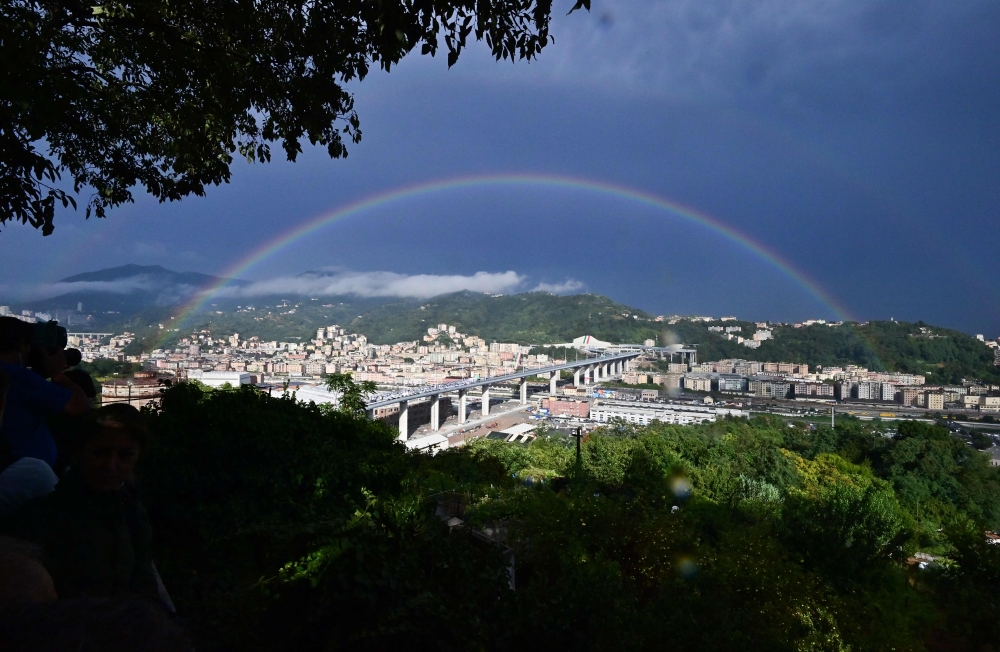 A rainbow is seen over the new San Giorgio bridge on the inauguration day on August 3 , 2020 in Genoa, the new high-tech structure will have four maintenance robots running along its length to spot weathering or erosion, as well as a special dehumidificat