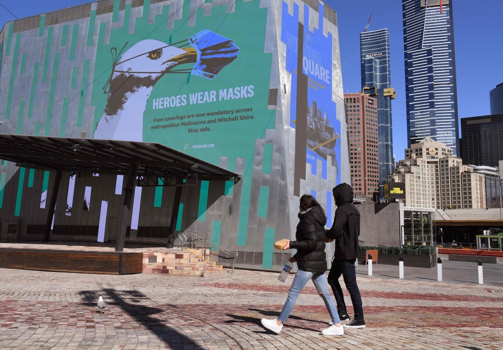 A sign in Federation Square urges people to wear a mask in the central business district in Melbourne on August 6, 2020. Australia's second city Melbourne entered a more restrictive six-week lockdown on August 6, sparking a fresh wave of anxiety and confu