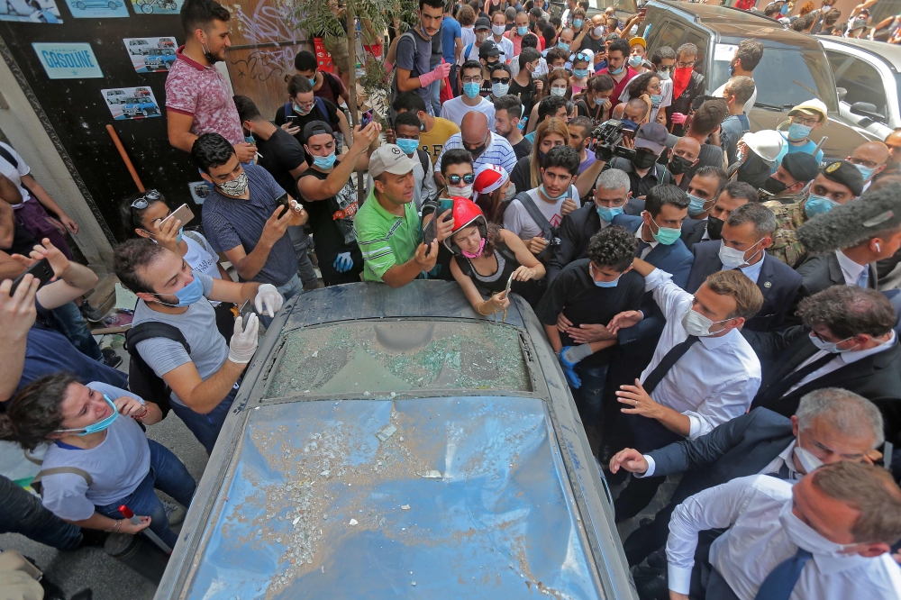 French President Emmanuel Macron talks to people during a visit to the Gemmayzeh neighbourhood, which has suffered extensive damage due to a massive explosion in the Lebanese capital, on August 6, 2020. AFP -