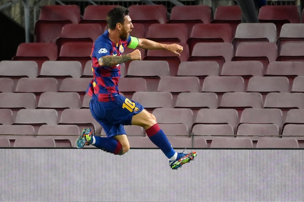 Barcelona's Argentine forward Lionel Messi celebrates after scoring a goal during the UEFA Champions League round of 16 second leg football match between FC Barcelona and Napoli at the Camp Nou stadium in Barcelona on August 8, 2020. / AFP / LLUIS GENE