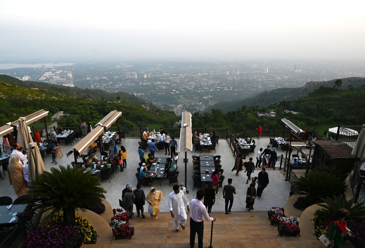 People arrive on the top of a restaurant on Margalla Hills in Islamabad on August 10, 2020, after government announced it would be lifting most of the country's remaining coronavirus restrictions after seeing new cases drop for several weeks. / AFP / Aami