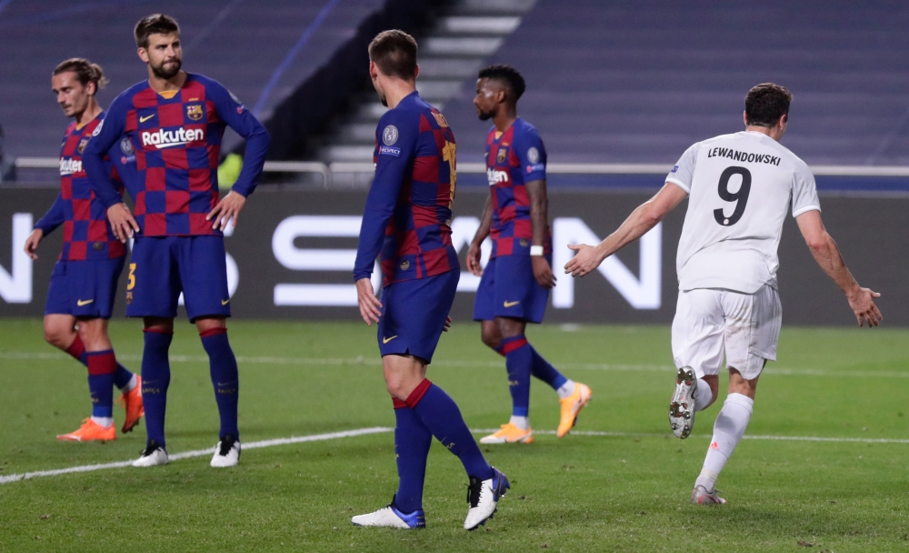 Bayern Munich's Polish forward Robert Lewandowski (R) celebrates after scoring his team's sixth goal during the UEFA Champions League quarter-final football match between Barcelona and Bayern Munich at the Luz stadium in Lisbon on August 14, 2020. / AFP /