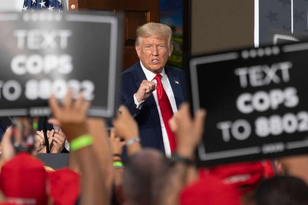 US President Donald Trump pumps his fist as he delivers remarks to the City of New York Police Benevolent Association at the Trump National Golf Club in Bedminster, NJ, on August 14, 2020. / AFP / JIM WATSON