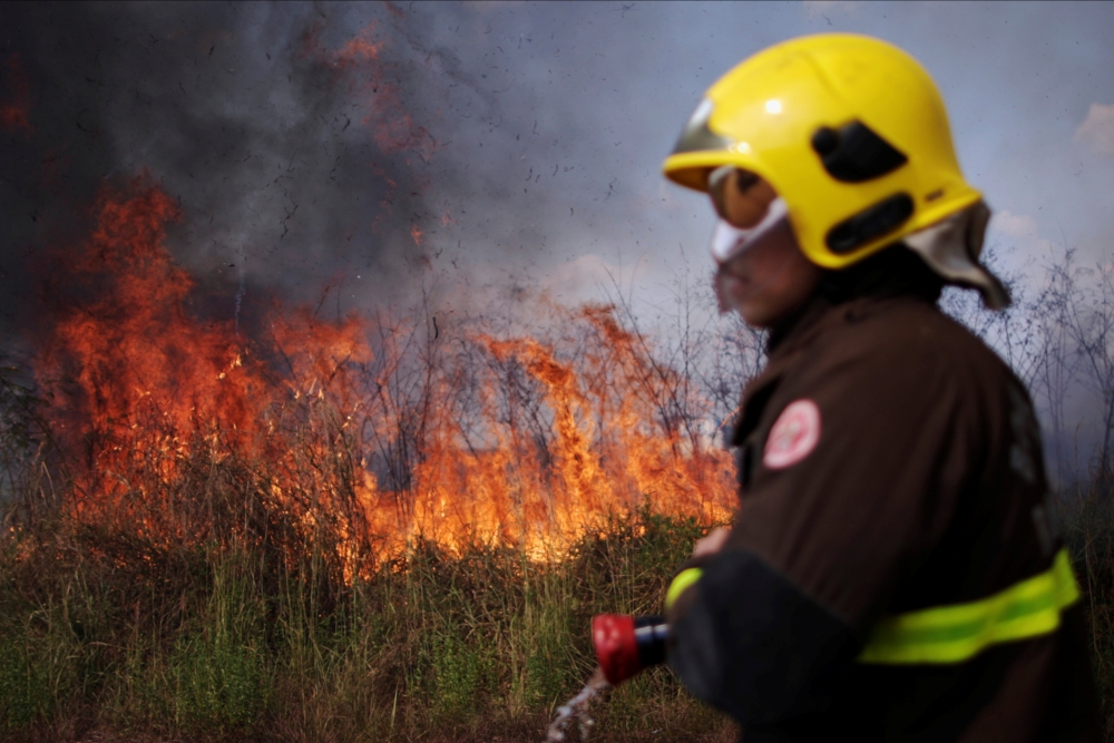 A firefighter monitors a spot fire in an area of the Amazon rainforest, near Porto Velho, Rondonia State, Brazil August 16, 2020. REUTERS/Ueslei Marcelino