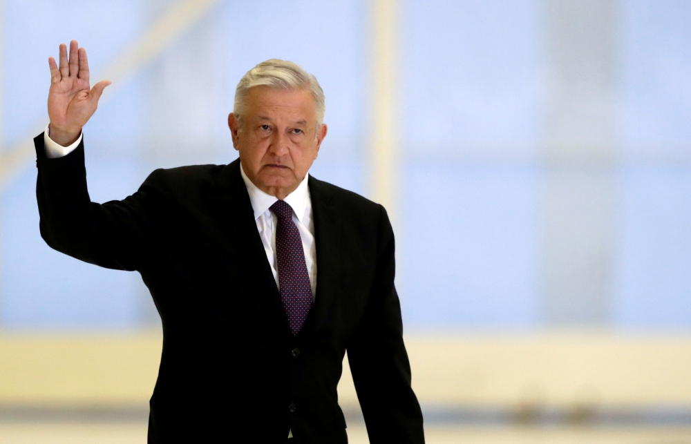 Mexico's President Andres Manuel Lopez Obrador waves as he arrives to hold a news conference at the presidential hangar, with the presidential plane in the background, at Benito Juarez International Airport in Mexico City, Mexico July 27, 2020. REUTERS/He