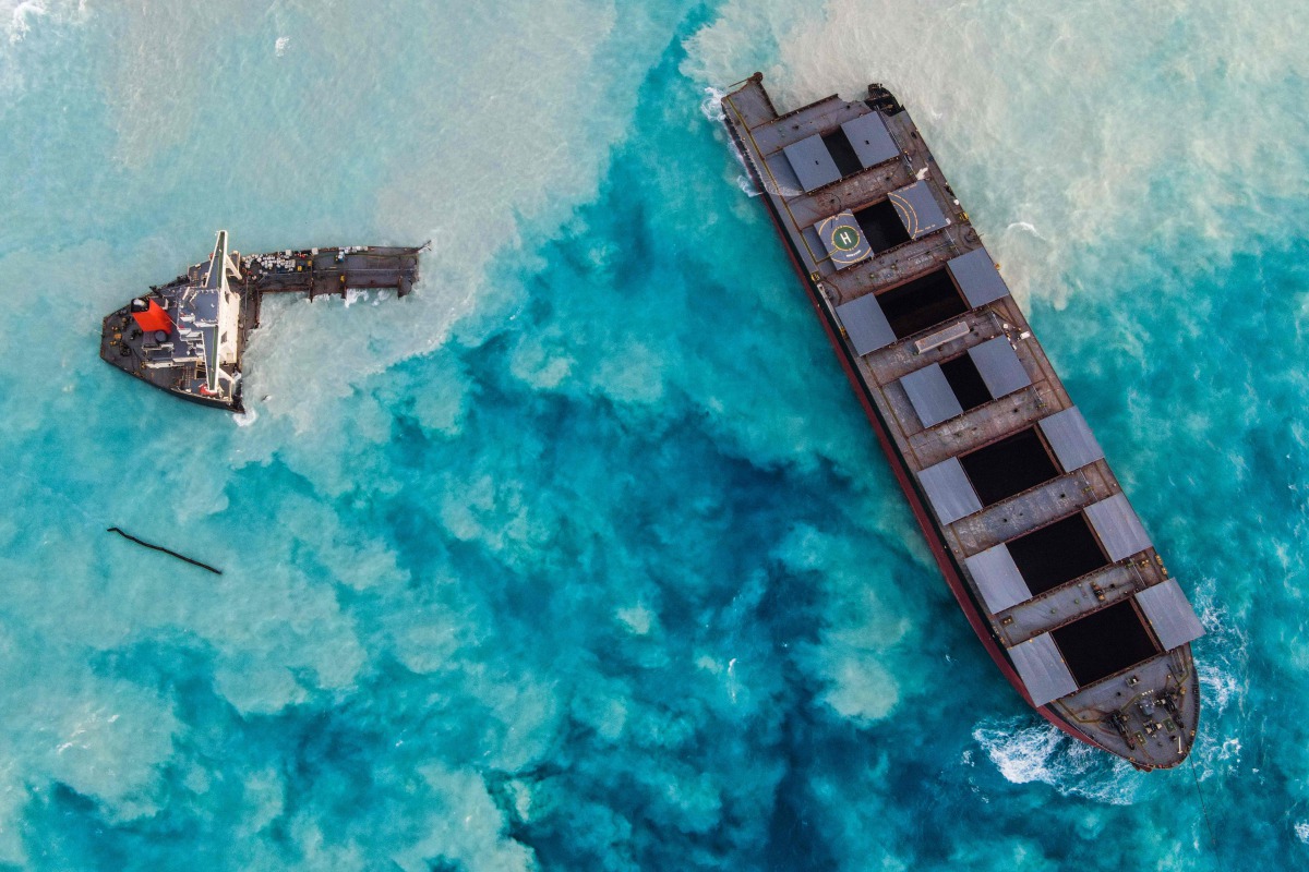 TOPSHOT - An aerial view taken in Mauritius on August 17, 2020, shows the MV Wakashio bulk carrier, belonging to a Japanese company but Panamanian-flagged, that had run aground and broke into two parts near Blue Bay Marine Park. / AFP / -