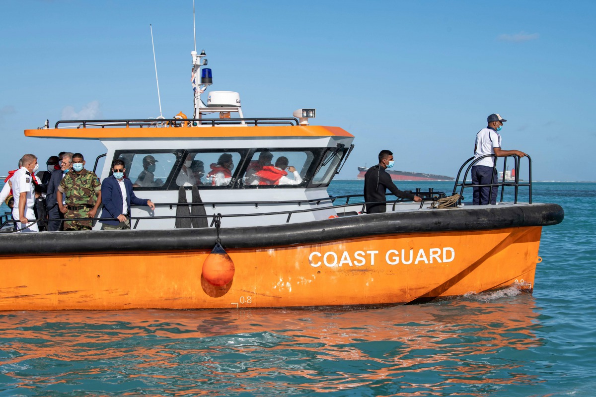 French Overseas Minister Sebastien Lecornu (R in the cabin) rides onboard Mauritius's coast guard boat on his way to visit the oil spill site caused by the agrounded vessel MV Wakashio, belonging to a Japanese company but Panamanian-flagged, in Mahebourg 