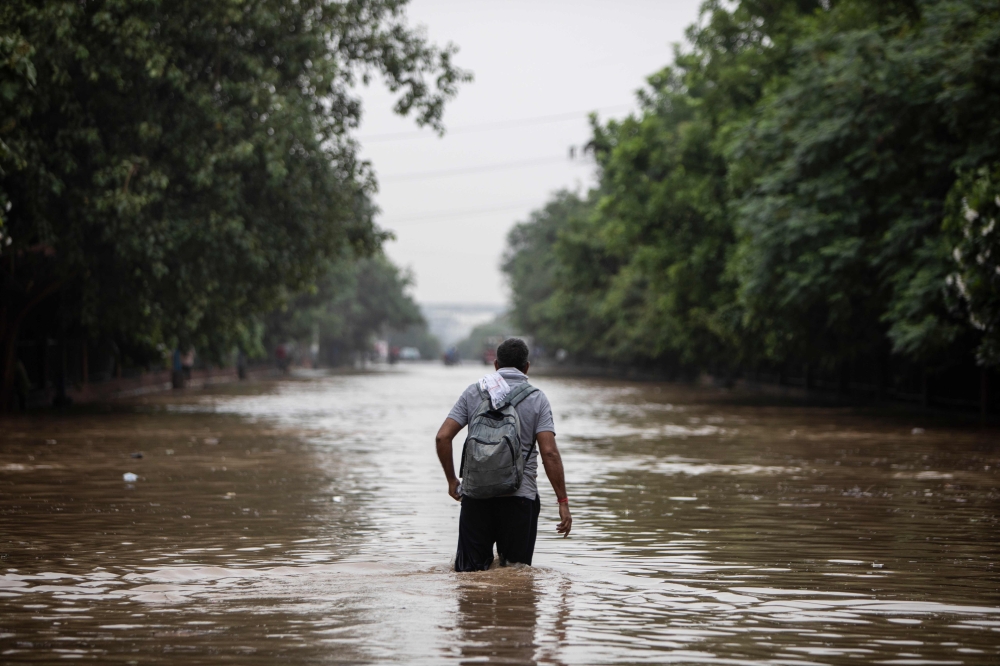 A man walks through a waterlogged street following monsoon rainfalls in Gurgaon on the outskirts of New Delhi on August 19, 2020. 