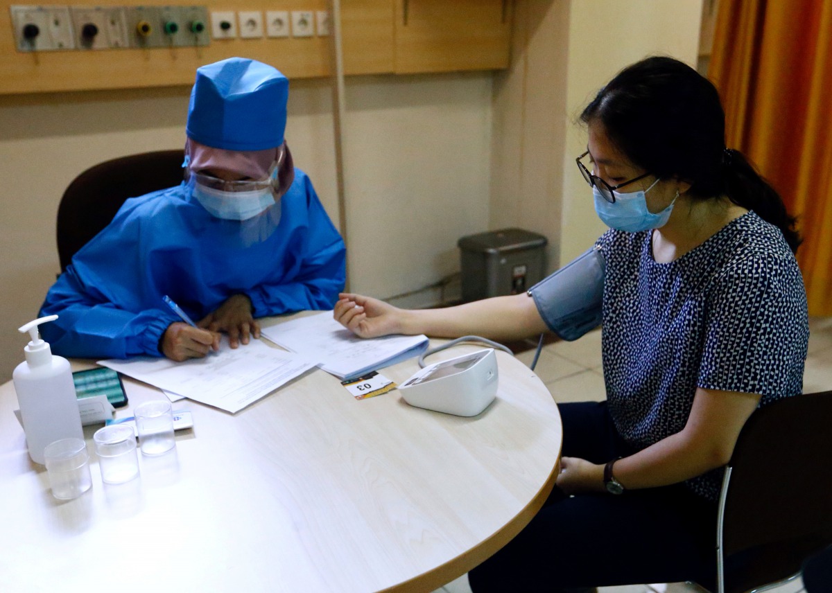 FILE PHOTO: FILE PHOTO: A healthcare worker checks the tension of a volunteer during a simulation for coronavirus vaccine clinical trials next week at the Faculty of Medicine at Padjadjaran University amid the COVID-19 pandemic in Bandung, Indonesia, Augu