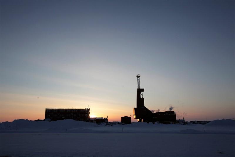 FILE PHOTO: The sun sets behind an oil drilling rig in Prudhoe Bay, Alaska on March 17, 2011. REUTERS/Lucas Jackson/File Photo - RC1C644EA560
