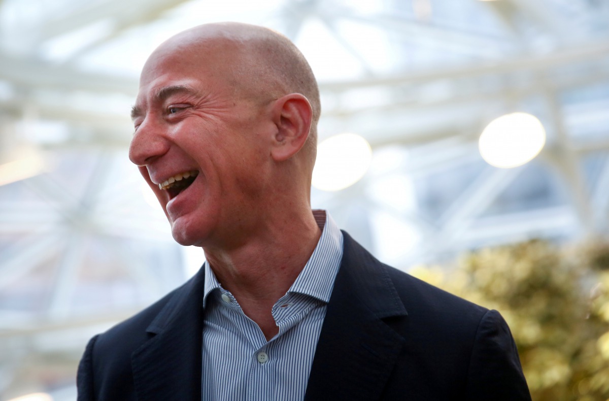 FILE PHOTO: Amazon founder and CEO Jeff Bezos laughs as he talks to the media while touring the new Amazon Spheres during the grand opening at Amazon's Seattle headquarters in Seattle, Washington, U.S., January 29, 2018. REUTERS/Lindsey Wasson/File Photo
