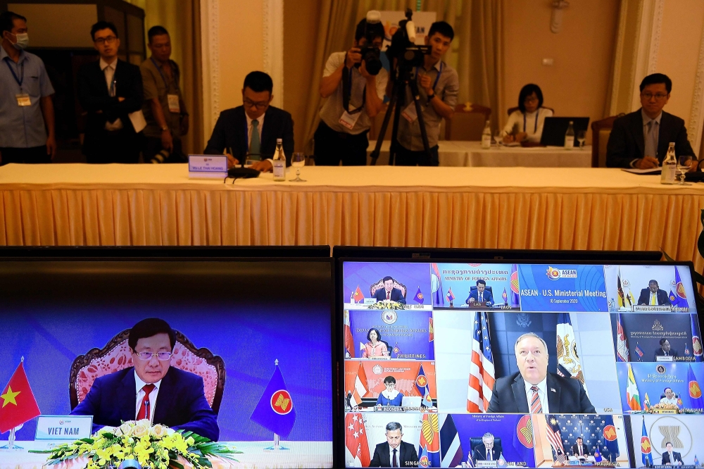 Vietnam's Foreign Minister Pham Binh Minh (L) and US Secretary of State Mike Pompeo (C, on screen at R) are seen on monitor screens during the Association of Southeast Asian Nations (ASEAN)-US Ministerial Meeting, held online due to the COVID-19 novel cor