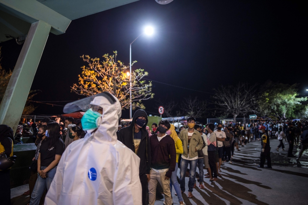 This picture taken on September 12, 2020 shows youths queueing to take the COVID-19 coronavirus rapid test in Surabaya, East Java. / AFP / Juni Kriswanto