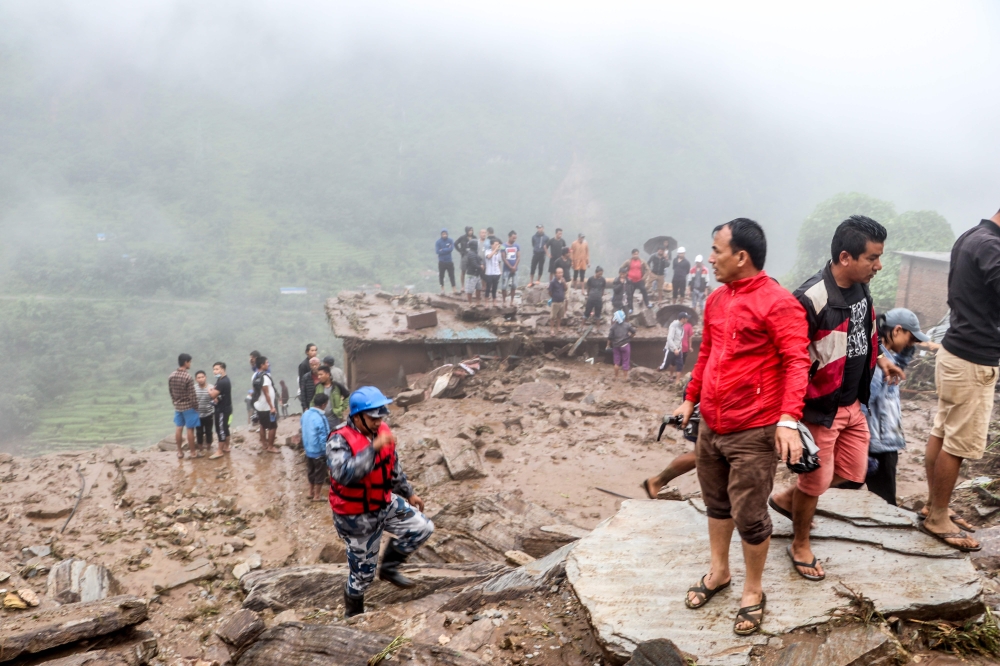 Rescue workers and residents gather for search at the scene of a landslide following heavy rains in Bahrabise municipality of Sindhupalchok district, some 90 kms northeast of Kathmandu on September 13, 2020. / AFP / NIROJ CHAOULAGAIN