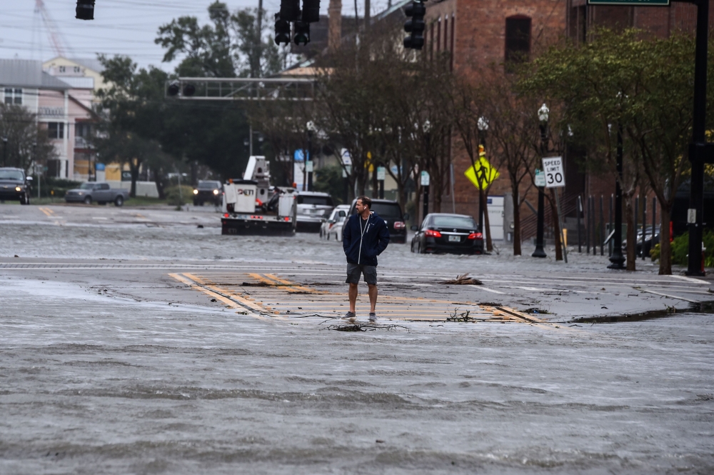 A man stands on a street flooded by Hurricane Sally in Pensacola, Florida, on September 16, 2020. Hurricane Sally barrelled into the US Gulf Coast early Wednesday, with forecasts of drenching rains that could provoke 