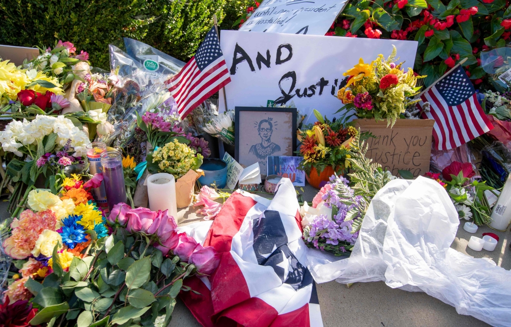 People leave flowers outside of the US Supreme Court in memory of Justice Ruth Bader Ginsburg, in Washington, DC, on September 19, 2020. Ginsburg died September 18, opening a crucial vacancy on the high court expected to set off a pitched political battle