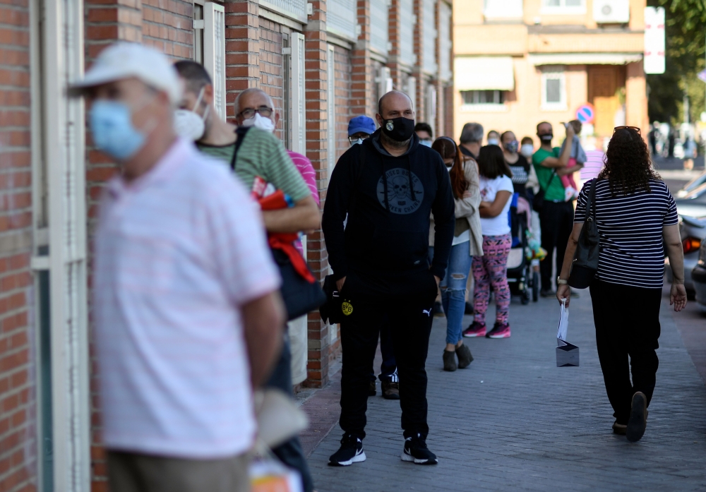 Residents queue to access the Cuzco healthcare centre in the under partial lockdown town of Fuenlabrada, in Madrid region, on September 22, 2020.   AFP / OSCAR DEL POZO