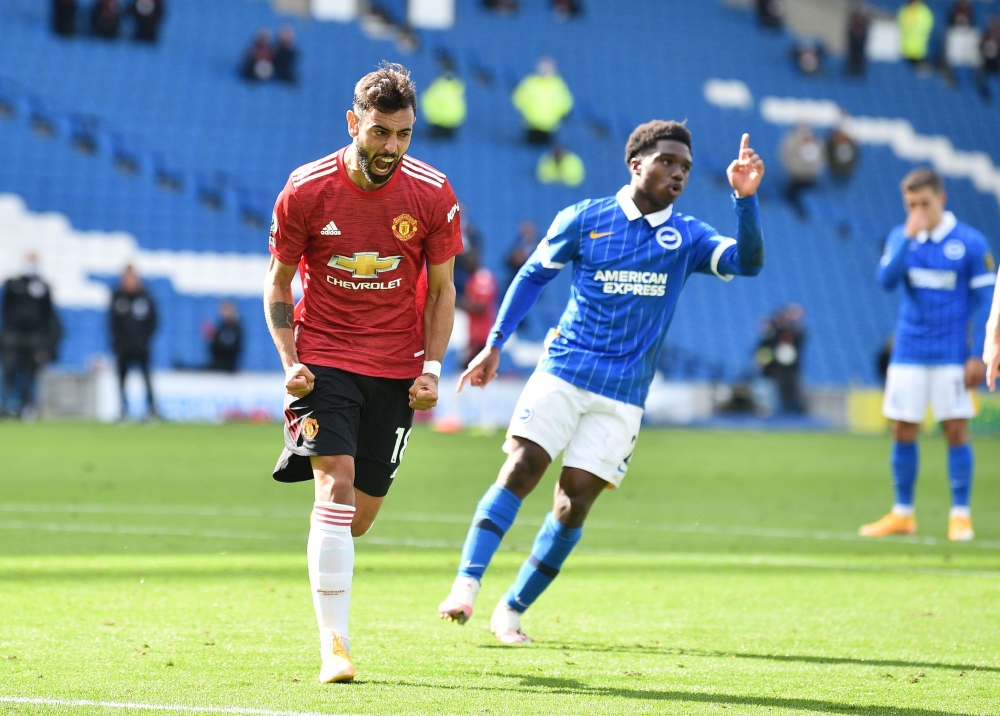 Manchester United's Bruno Fernandes celebrates scoring their third goal with teammates Pool via REUTERS/Glyn Kirk 