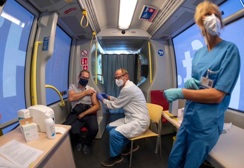 A man receives a flu vaccine inside the mobile vaccination station 