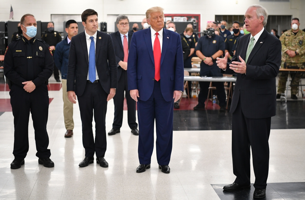 US President Donald Trump (C) listens to US Senator Ron Johnson (R), Republican of Wisconsin, during a tour of an emergency operations center at Mary D. Bradford High School in Kenosha. AFP / MANDEL NGAN
