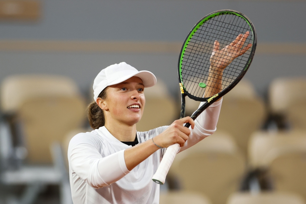 Poland's Iga Swiatek celebrates after winning against Romania's Simona Halep during their women's singles fourth round tennis match on Day 8 of The Roland Garros 2020 French Open tennis tournament in Paris on October 4, 2020. / AFP / Thomas SAMSON