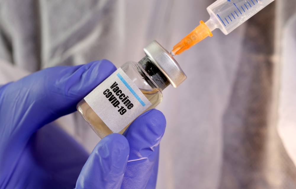 A woman holds a small bottle labeled with a 