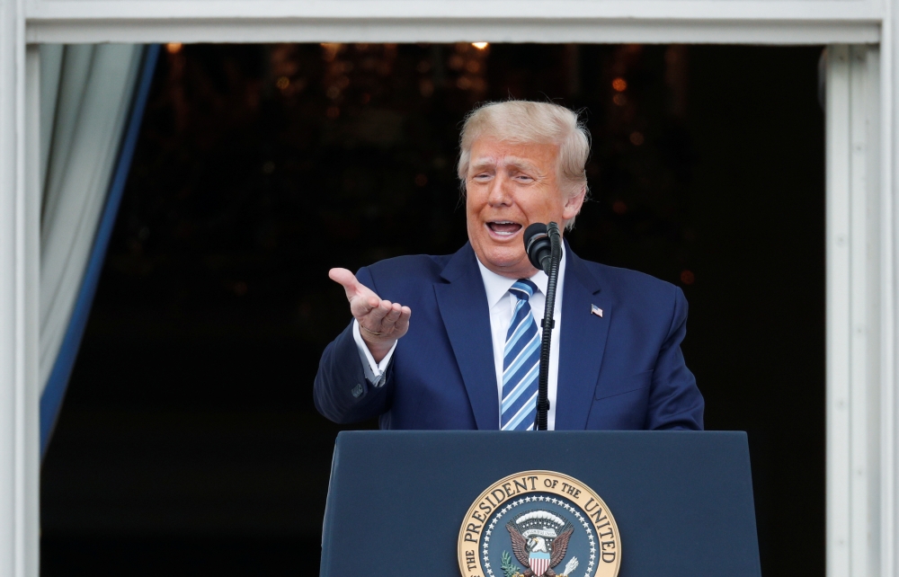 US President Donald Trump stands on a White House balcony speaking to supporters gathered on the South Lawn for a campaign rally that the White House is calling a 