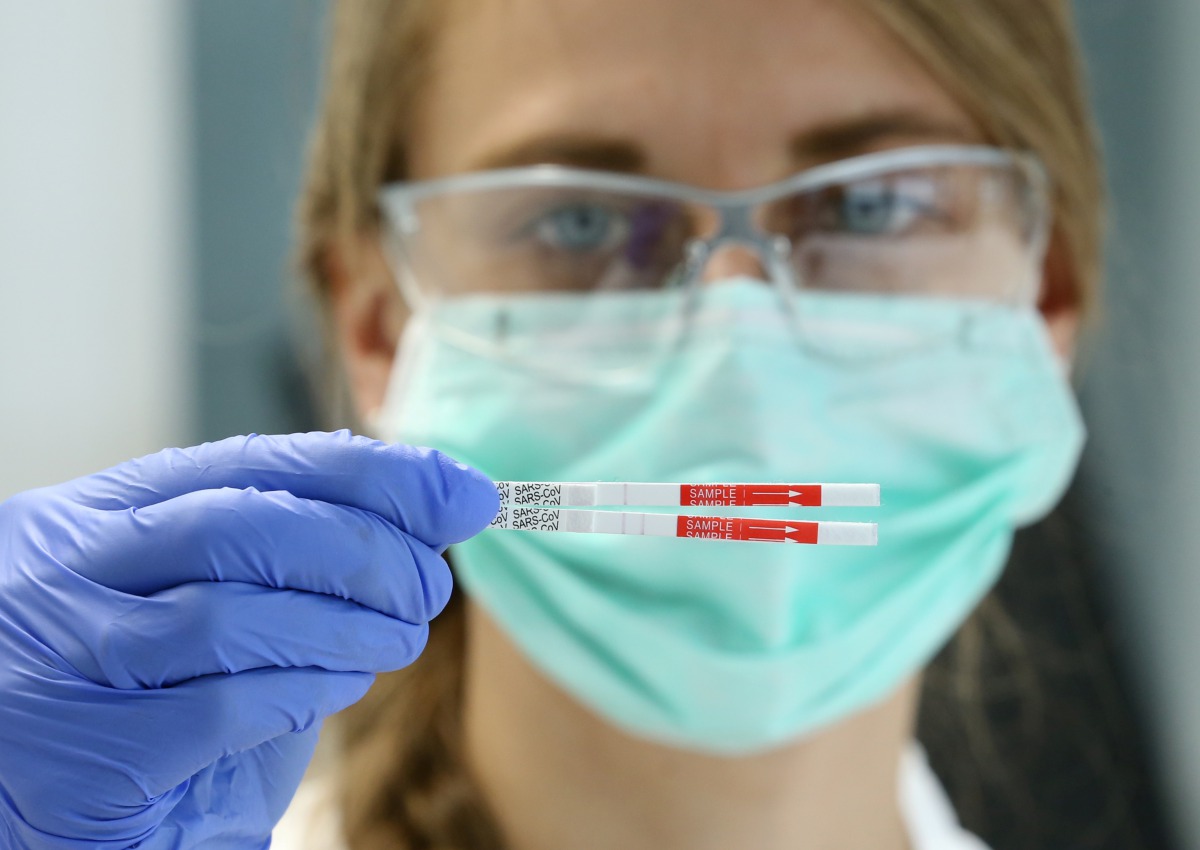 An employee of the diagnostics provider R-Biopharm displays two diagnostic test strips of a rapid antigen test to detect the SARS-CoV-2 antigen at their laboratory in Pfungstadt near Darmstadt, Germany October 8, 2020. REUTERS/Ralph Orlowski
