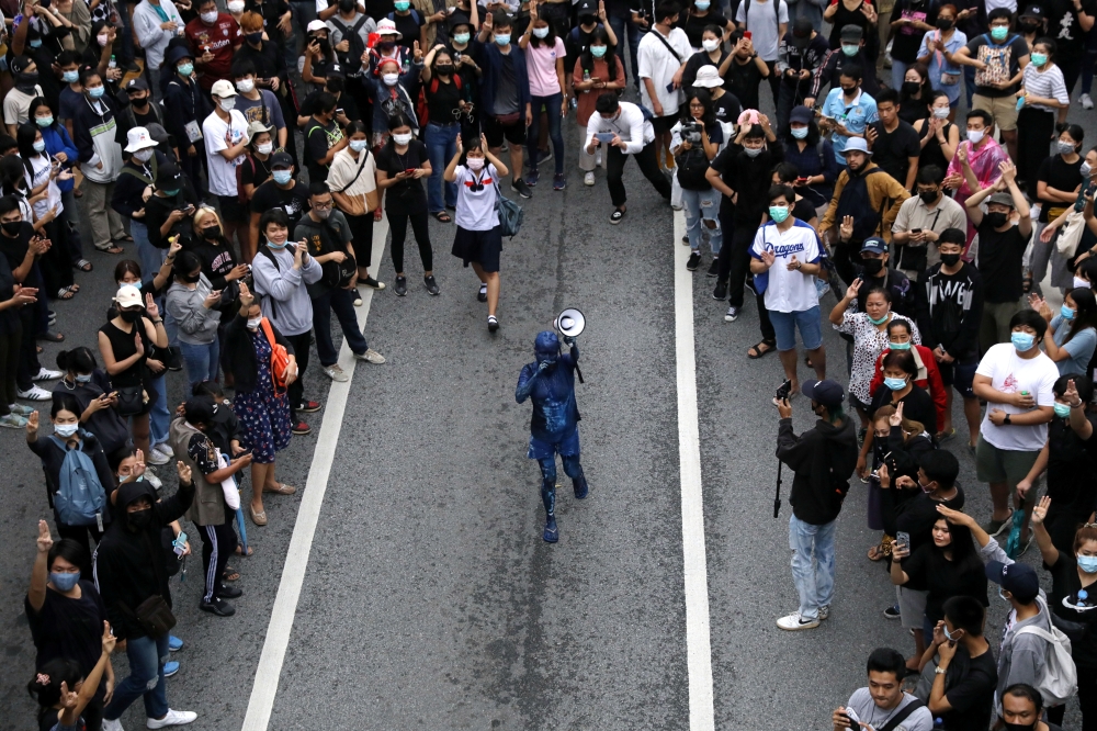 A pro-democracy activist covered in blue paint uses a megaphone during an anti-government protest, in Bangkok, Thailand October 17, 2020. REUTERS/Soe Zeya Tun