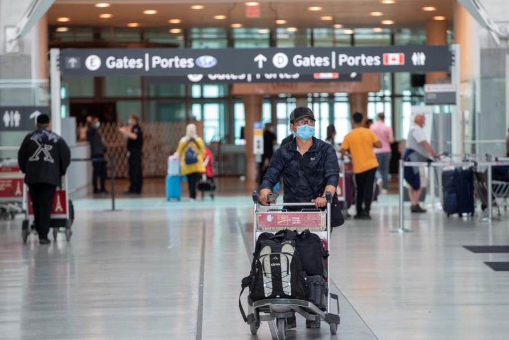 FILE PHOTO: A passengers wears a mask which is now mandatory as a 