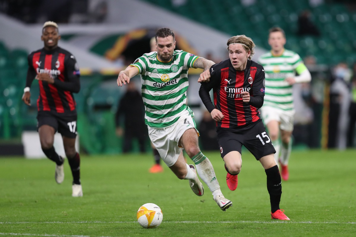 AC Milan's Norwegian midfielder Jens Petter Hauge (R) vies with Celtic's Scottish defender Jack Hendry and scores his team's third goal during the UEFA Europa League 1st round group H football match between Celtic and AC Milan at Celtic Park stadium in Gl
